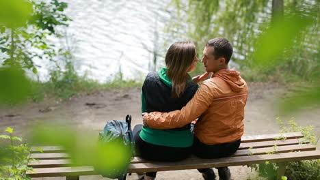 couple on bench in nature. happy young couple in love sitting on a park bench