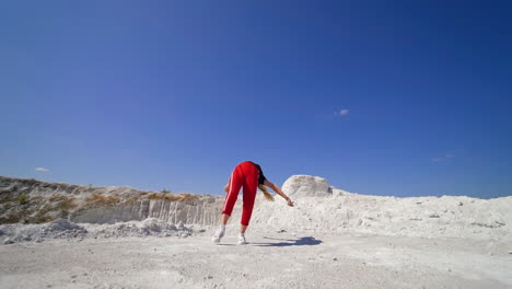 woman performing breakdance moves in a quarry