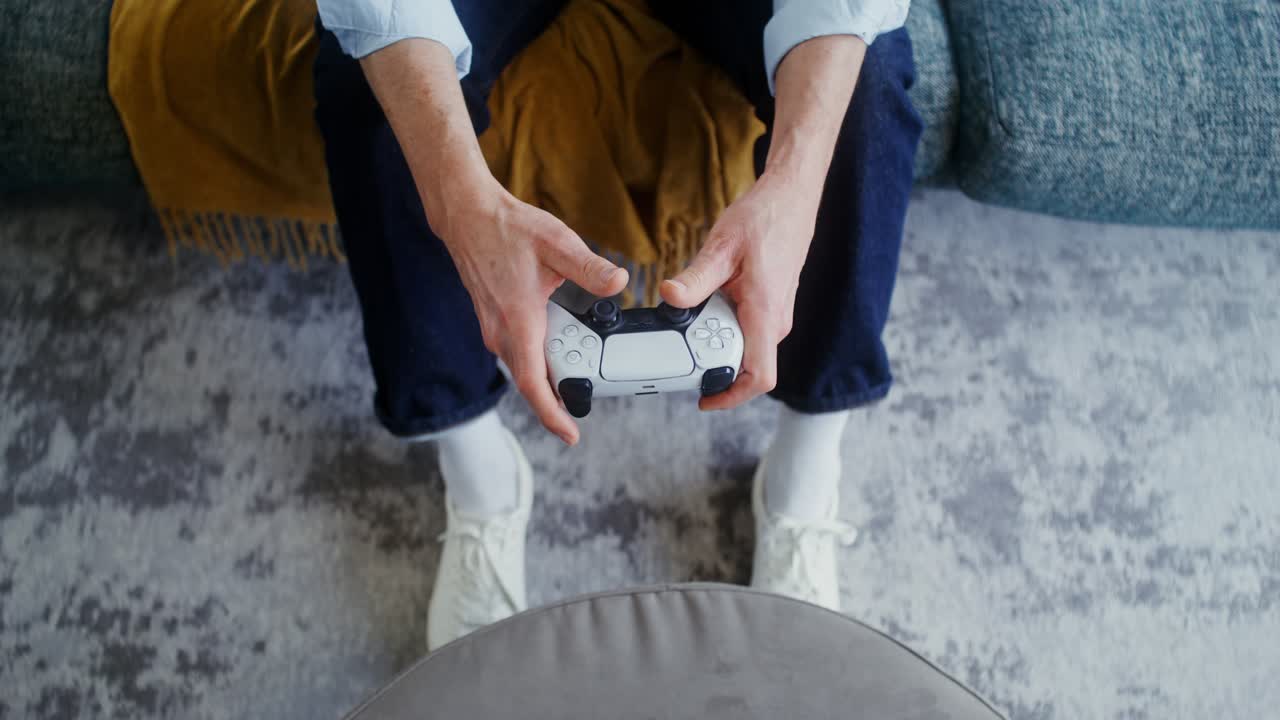 Person holding a Playstation game controller