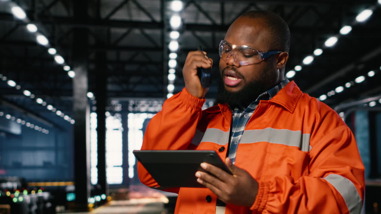 African american professional worker using walkie talkie radio in industry plant