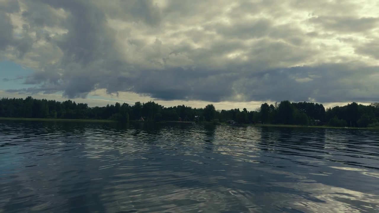 Scenic freshwater lake with trees and small houses visible along the distant shoreline.