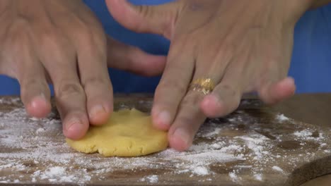 la mano de la mujer chef está aplanando la masa de las galletas