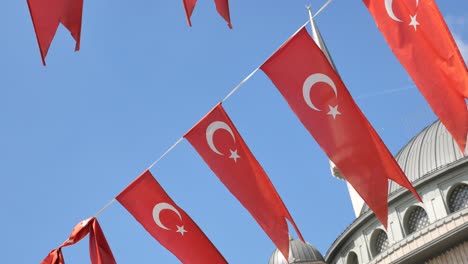 turkish flags hanging in front of a mosque