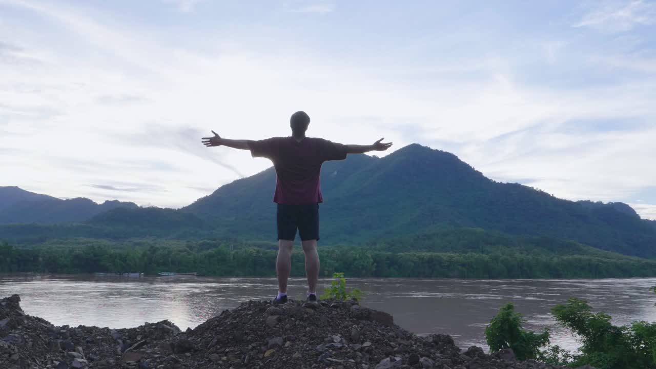 Man enjoying a view of mountains and river