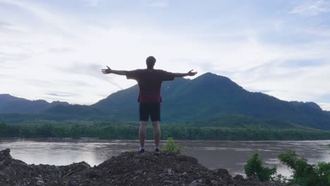 man enjoying a view of mountains and river