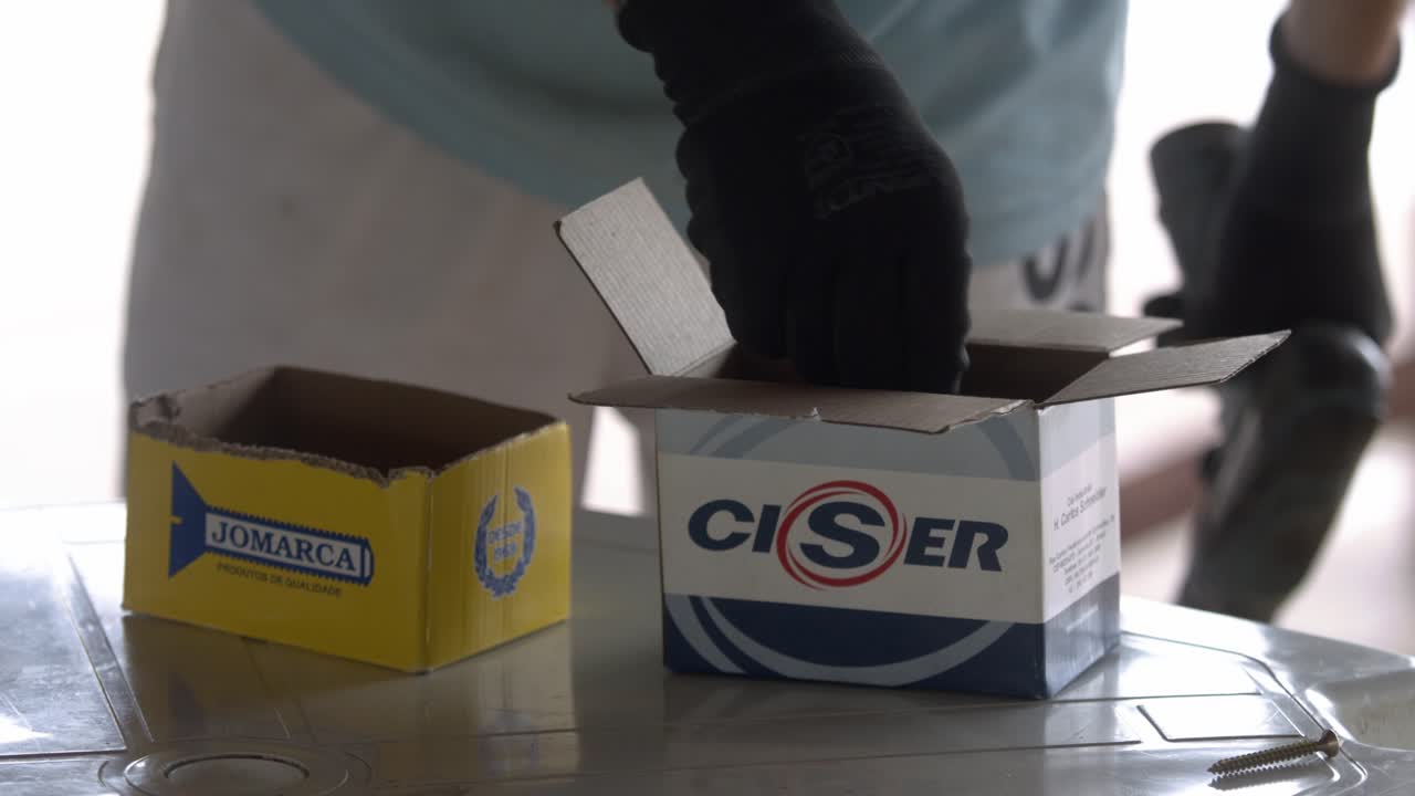 Person Assembling Screws from Boxes