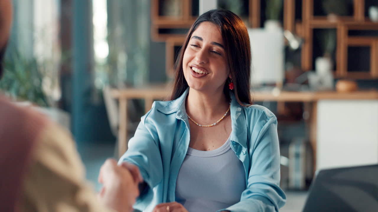 Giovane donna che parla e si stringe la mano in un ufficio moderno