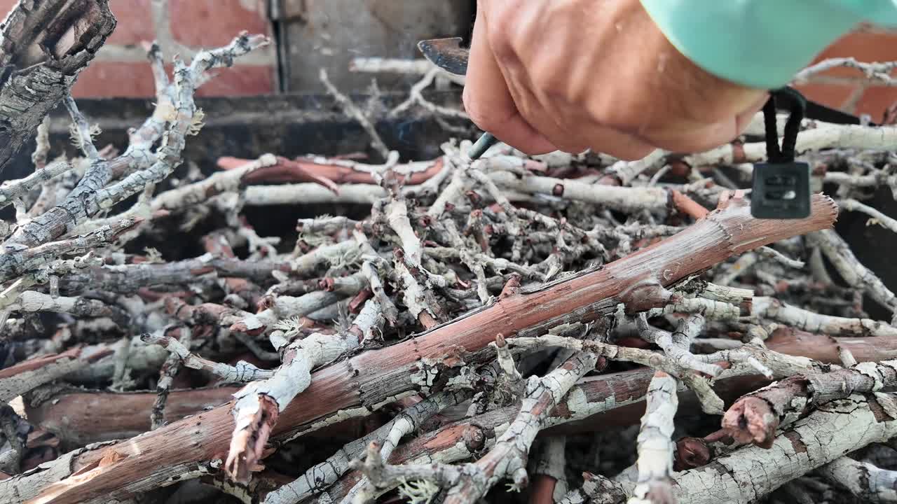 Bushcraft Skills: A Man Making Fire from Dry Wood Branches