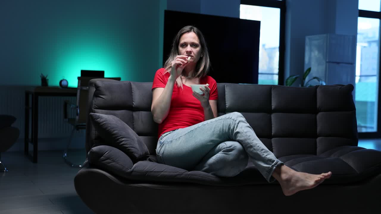 Woman Eating on Couch at Home