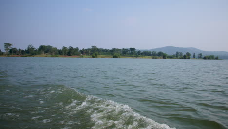 serene kabini river with a lush green nagarahole forest in the background, viewed from a moving boat.