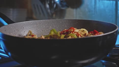 wok filled with meat and vegetables being cooked for homemade mexican food