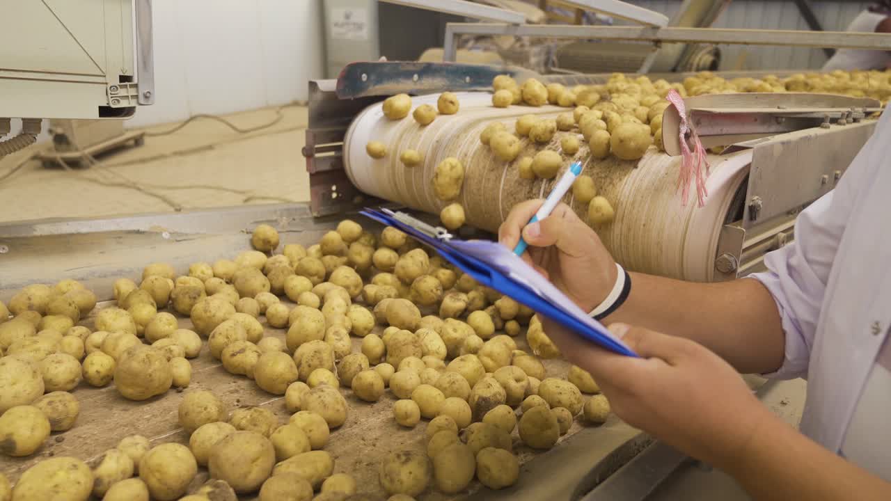 trabajador agrícola tomando notas en una instalación de almacenamiento de patatas.