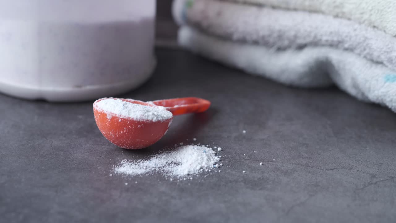 세탁용 세제와 수건을 가진 측정 스쿠프