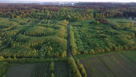 AERIAL-Flying-away-shot-of-Vilnius-Hinterland-with-the-City-of-Vilnius-in-the-distance,-Lithuania