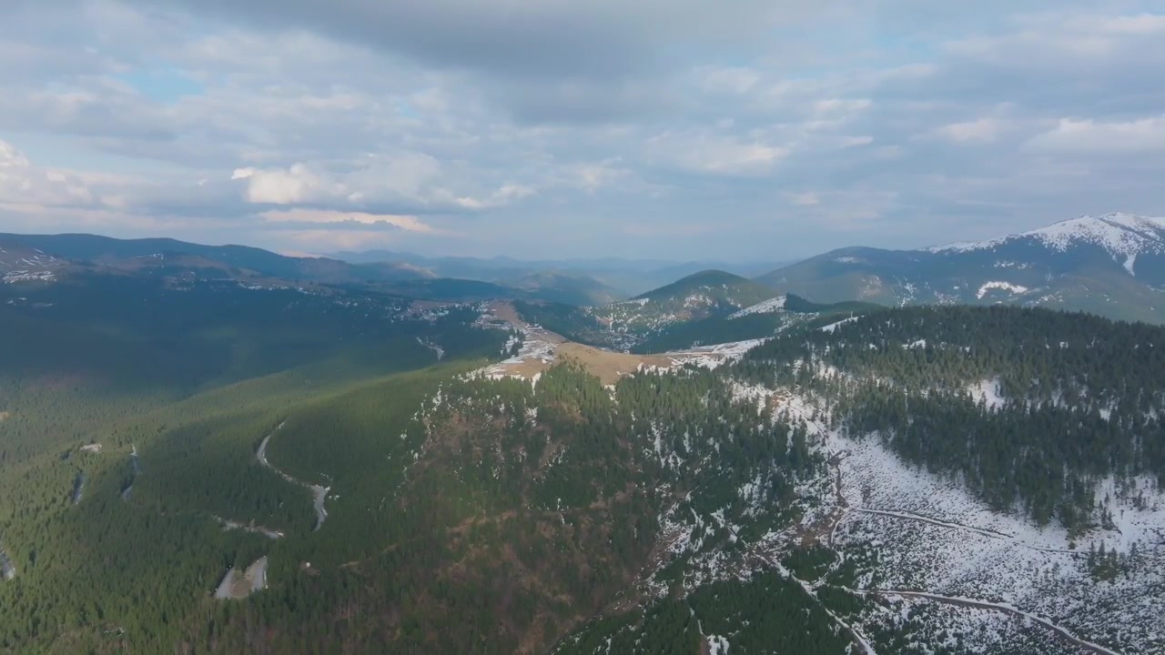 Vista drone sui Monti Rodnei con pendii innevati e raggi di sole, Romania