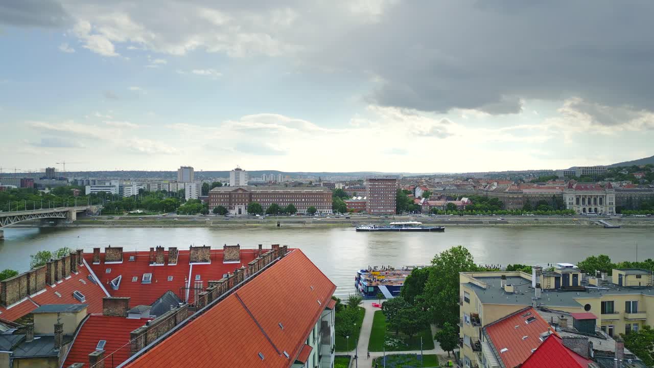 Aerial drone shot over Budapest, showcasing the Danube River winding through the city, with historic and modern architecture.