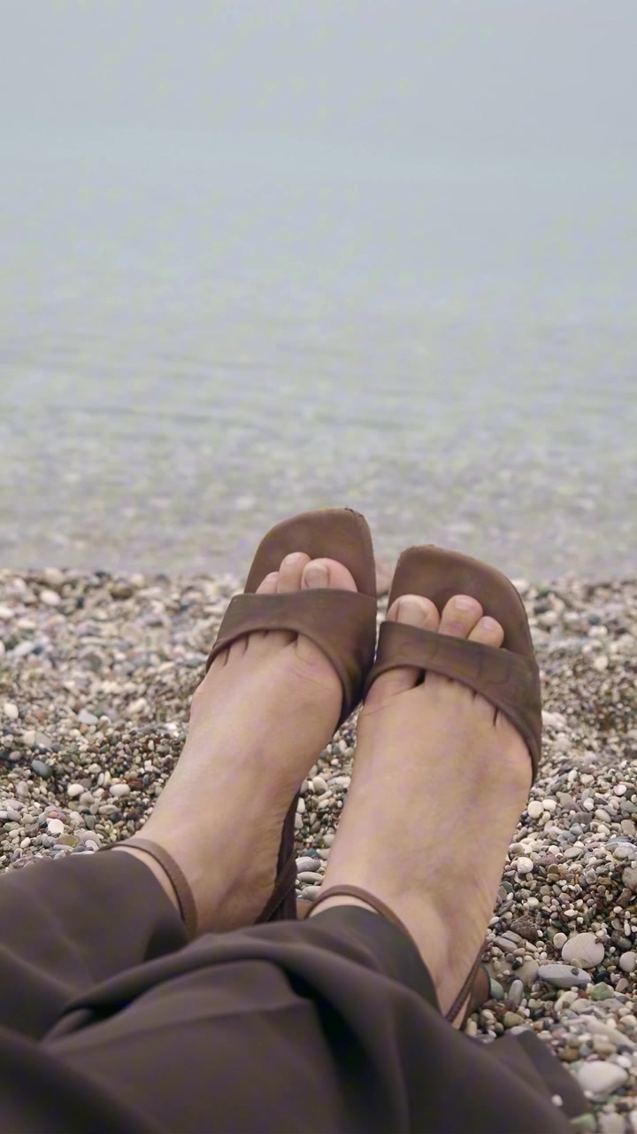Donna che si rilassa su una spiaggia di ciottoli in riva al mare