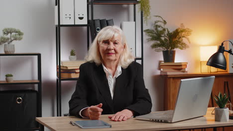 upset senior businesswoman girl showing thumb down gesture expressing bad work at home office table