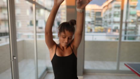 mujer feliz bailando en un balcón