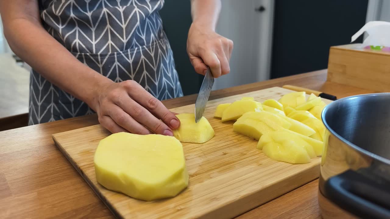 mujer cortando patatas en la cocina