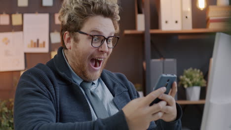 surprised man looking at his smartphone in the office