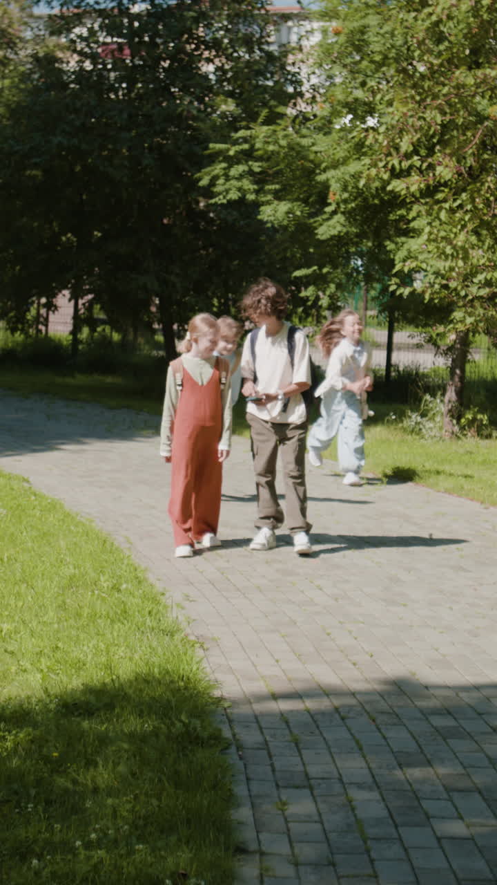 A group of children walking together on a paved path in a park