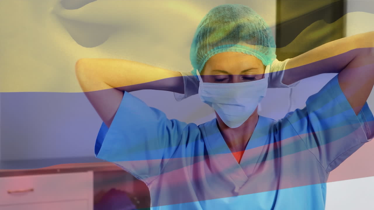 Animation of flag of cameroon waving over female surgeon in operating theatre