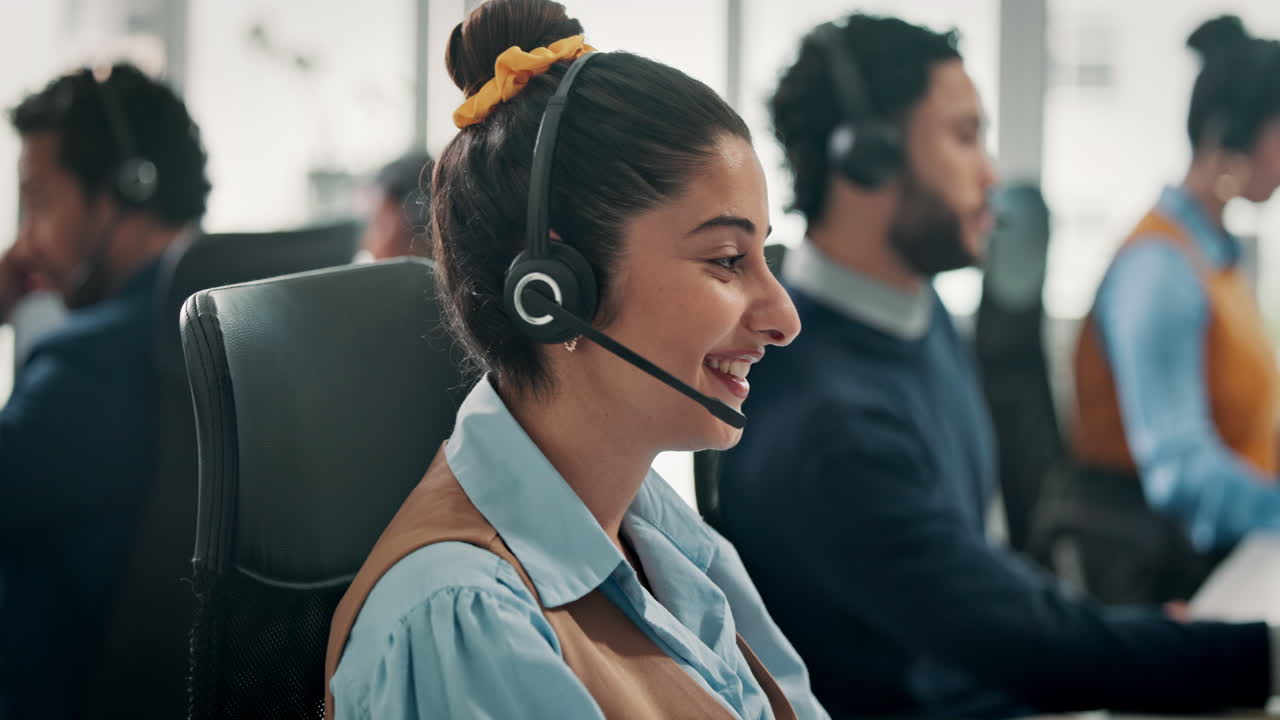 Donna amichevole con le cuffie che lavora in un affollato ufficio di call center
