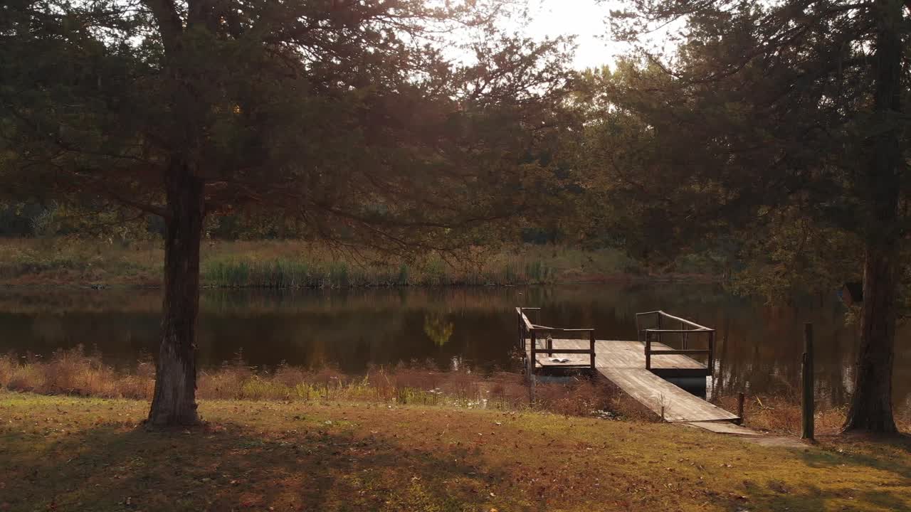 Tranquillo pontile in legno su uno stagno sereno circondato da alberi autunnali