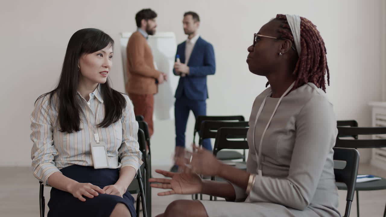 African and Asian Female Colleagues Talking