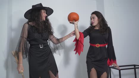 two witches with a pumpkin