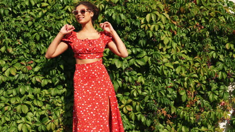 mujer con vestido floral rojo y gafas de sol