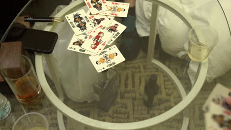 people playing a typical card game in hong kong, on a glass table