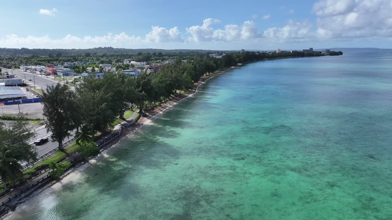 Trace the path of endurance in paradise. This sweeping aerial footage captures the renowned coastal running course along Saipan's west coast, famous for hosting international marathons. Stretching fro