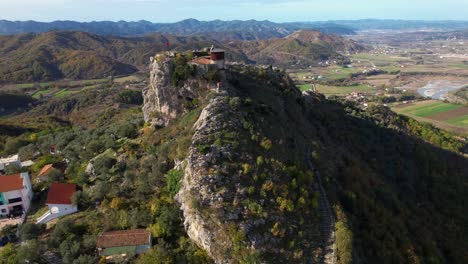 guardián de los picos: vista aérea de la antigua fortaleza situada en alturas rocosas, con vistas a majestuosas montañas y colinas en albania