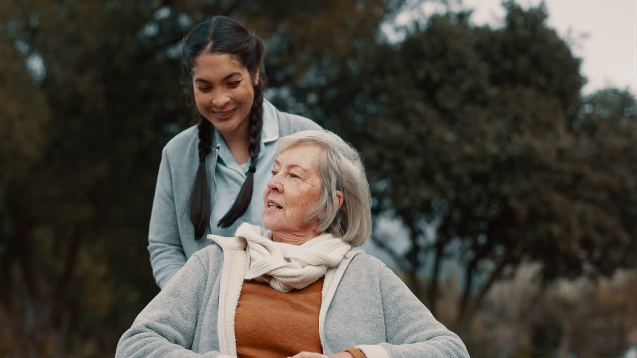 노인 여성, 간병인과 함께 대화하고 야외에서