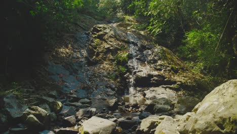 Una-Serena-Cascada-Cae-Sobre-Un-Terreno-Rocoso-Rodeado-De-Exuberante-Vegetación-En-El-Parque-Nacional-De-Khao-Sok