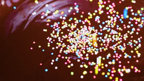 colorful sprinkles scatter over smooth chocolate