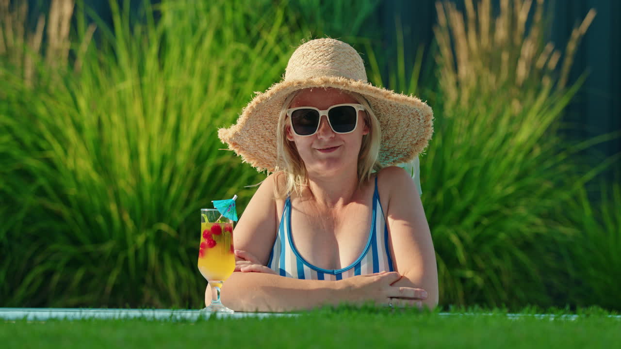 Kvinna som kopplar av vid poolen med en cocktail