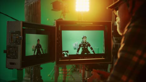 director looks at displays directs green screen cgi scene with actor wearing motion tracking suit and head rig. in the big film studio professional crew shooting blockbuster movie