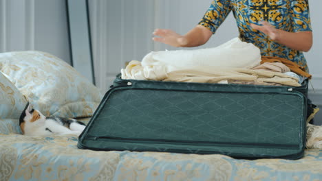 unrecognizable woman is packing in a travel bag get ready for a trip or business trip concept