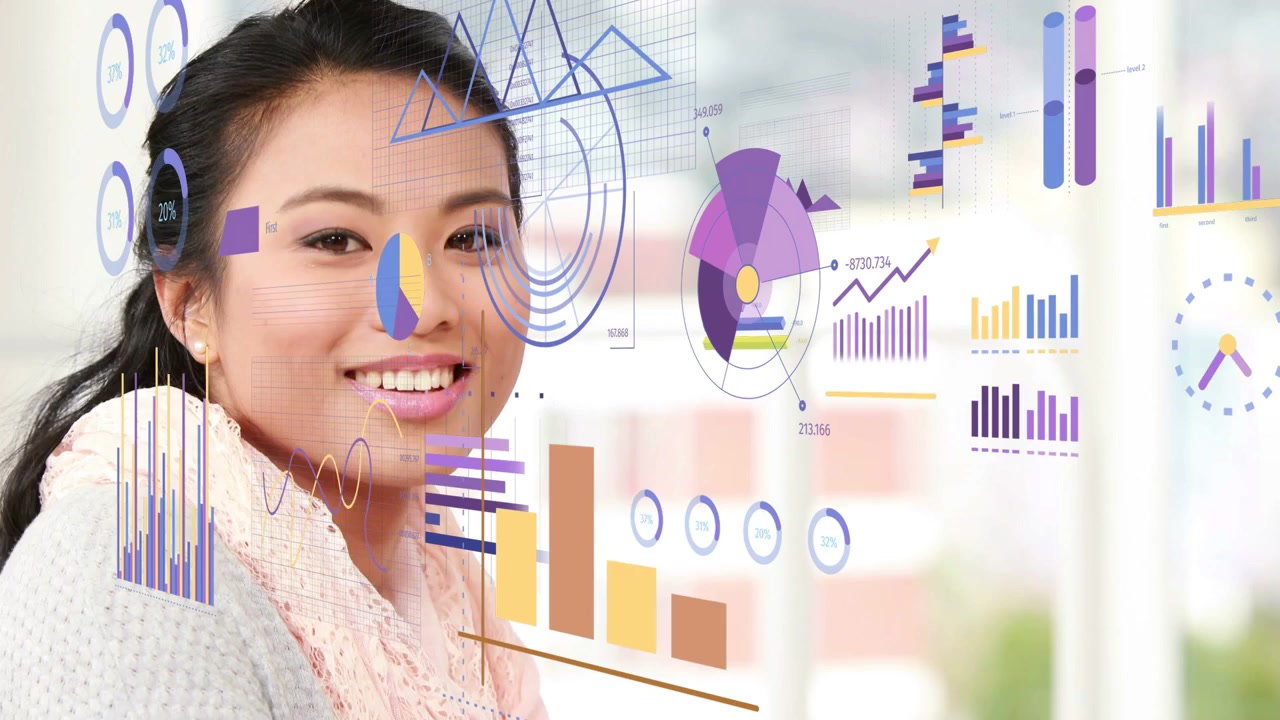 Woman typing, noticing animated business graphs on monitor, switching to pen, writing insights