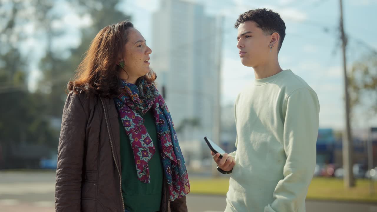 Two Individuals Engaging in an Outdoor Conversation on a City Street