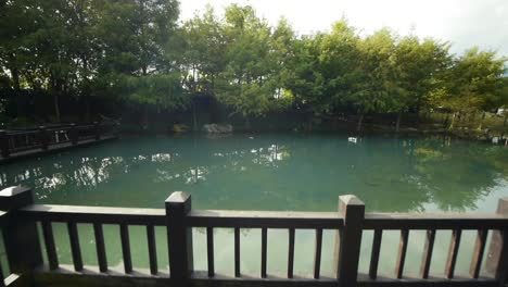 walking on viewing platform on pond with trees and mountains in landscape