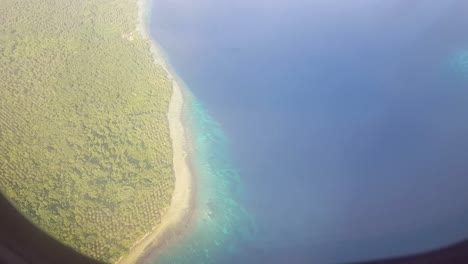 a tropical island, atoll, islet with stunning blue ocean as seen from a plane window in bougainville, papua new guinea