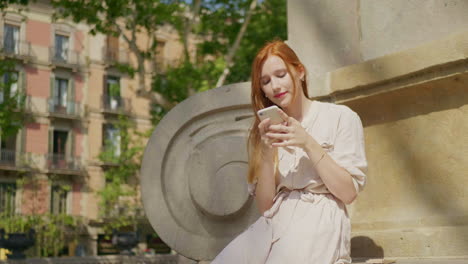 Close-up-view-of-focused-woman-scrolling-smartphone-outdoor