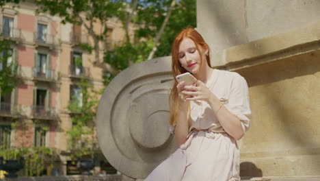 close-up view of focused woman scrolling smartphone outdoor