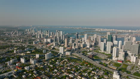 Cinematic-shot-of-urban-borough.-Concrete-jungle,-aerial-panoramic-view-of-modern-buildings-and-busy-trunk-road.-Miami,-USA
