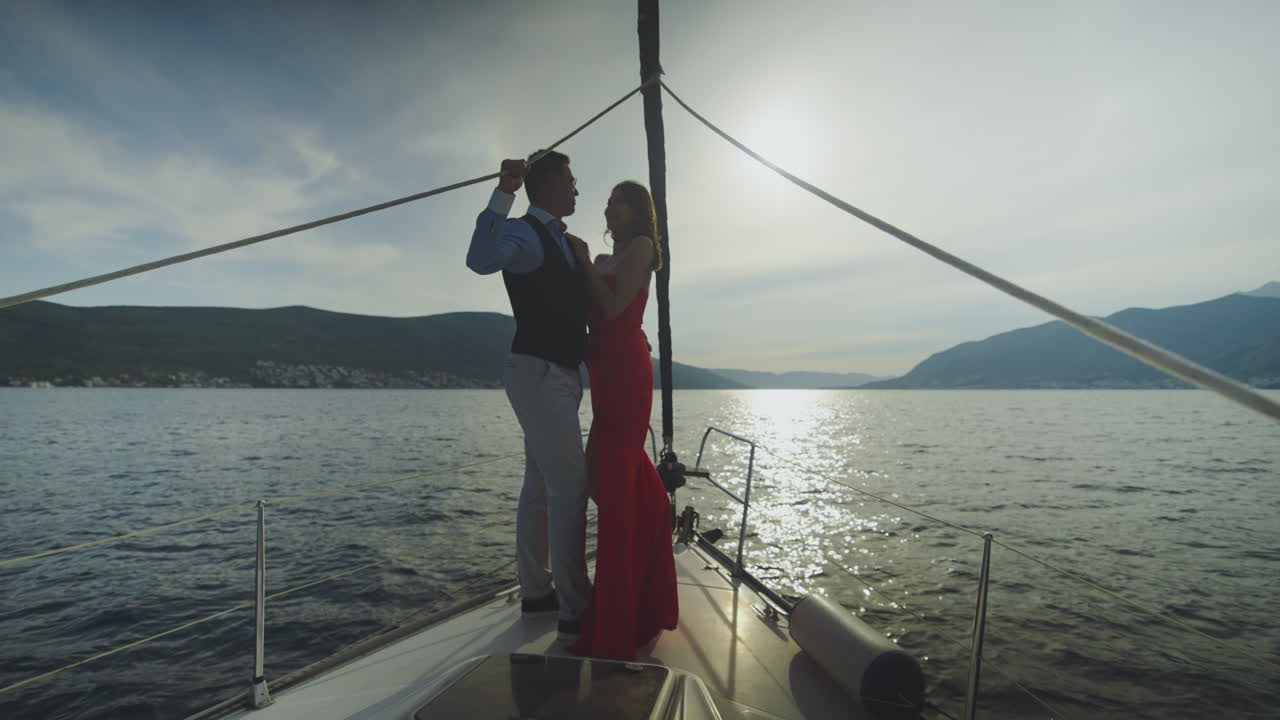 Una pareja en un yate al atardecer.