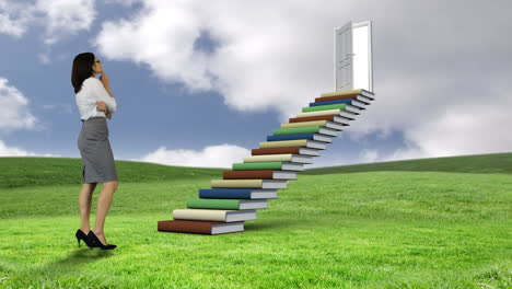 businesswoman looking at stair made of books on a green commun ground